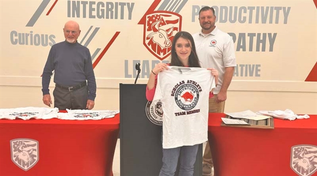 Tennis player holding up Booster Club shirt