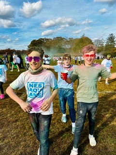 Students with color paint on them posing for picture