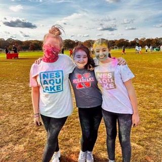 Students with color paint on them posing for picture