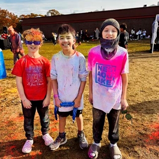 Students with color paint on them posing for picture