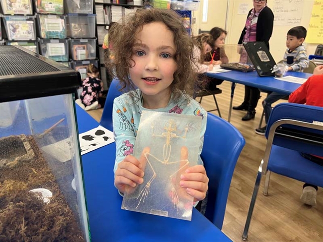 student holding a small skeleton