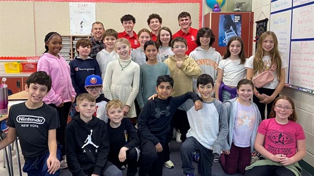 High School students and elementary students posing for picture