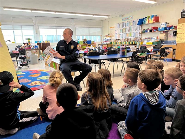 Police officer reading to students