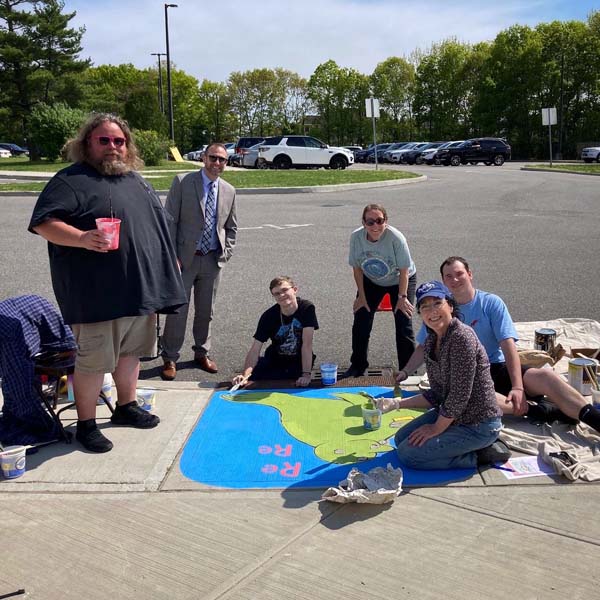 people around painted storm drain