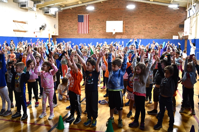 Students in school watching Sparky the mascot