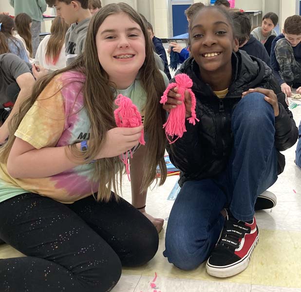 students with yarn dolls