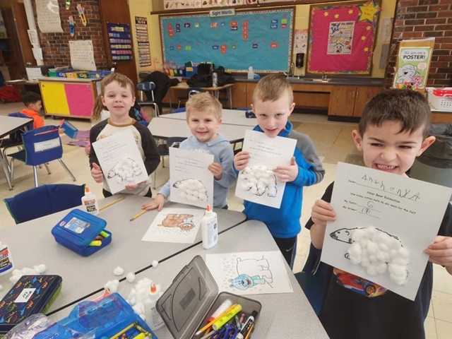students in class with paper penguins