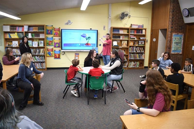 students reading a book using sign language