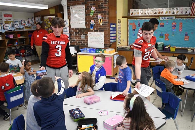 football students talking with kindergarten students