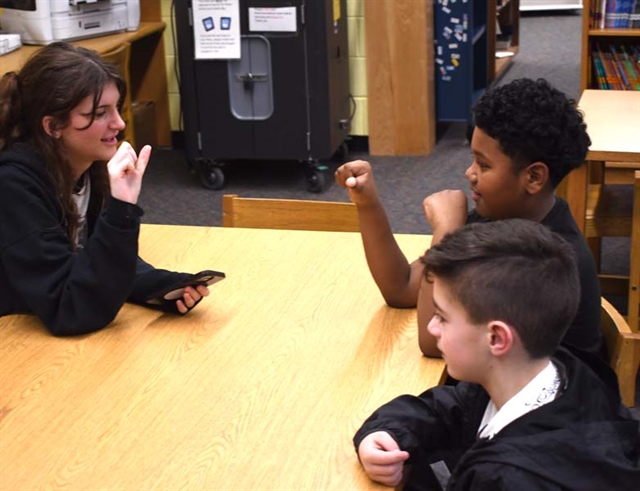 students reading a book using sign language