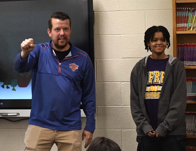 HS students teaching sign language to elementary students